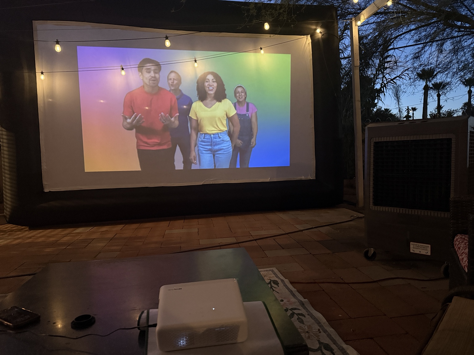 Colorful karaoke performance playing on a giant backyard screen
